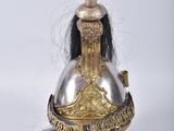 a gold helmet with a red feather on top of it