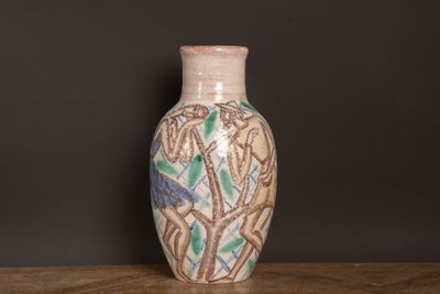 un vase posé sur une table devant un mur noir