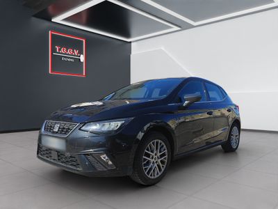 Une voiture noire est garée dans un showroom où une affiche est accrochée au mur.