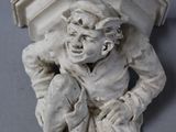 a small statue of a boy sitting on a ledge
