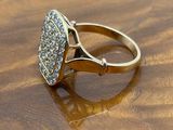 an image of a gold ring with diamonds on a wooden surface
