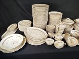 many plates and bowls on a table with a black background