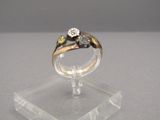a gold ring with a diamond on it on a clear stand