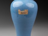 a blue vase sitting on a table with a tag on it