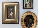 three framed pictures hanging on the wall next to a mirror