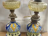 pair of blue and yellow vases on wooden table with white curtain in background