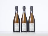 three bottles of wine sitting on top of a white table