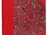 un vieux livre avec une couverture rouge et un motif dessus