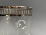 un vase en verre transparent muni d'un couvercle et d'un rebord en argent