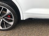 a close up of the front wheel of a white car