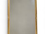 a large gold framed mirror with a decorative design