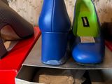pair of blue high heeled shoes sitting on top of a box