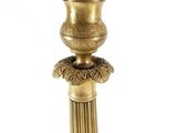 a gold vase that is sitting on a pedestal