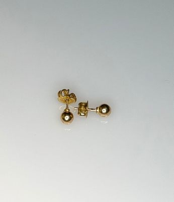 a small pair of gold earrings on a white surface