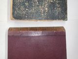 two old books sitting on top of a table next to each other