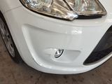 a close up of a car ' s headlight and front bumper