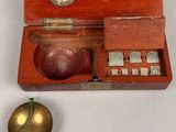 a small wooden box with a metal object inside of it