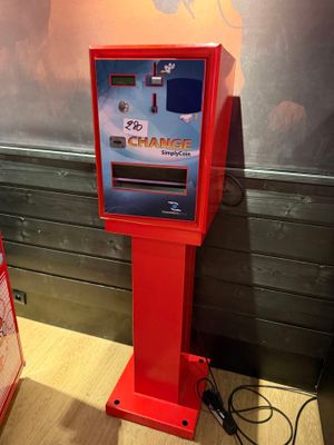 a red vending machine sitting on the floor next to a sign