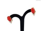 a close up of a pair of earrings on a black stand