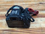 a camera on a wooden table with a cord attached to it