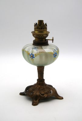une lampe à huile ancienne posée sur un socle, sur fond blanc