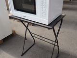 a white microwave sitting on top of a folding table