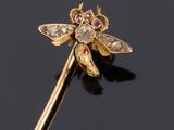 a close up of a gold and diamond dragonfly broochle