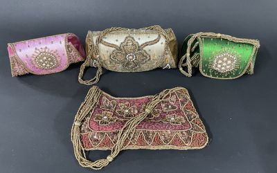 three small purses are lined up on a black surface