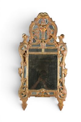 un miroir avec un cadre doré sur un mur blanc
