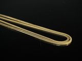a close up of a gold chain on a black surface