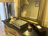 a dresser with a mirror and a lamp on top of it