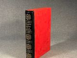 a red book sitting on top of a gray surface