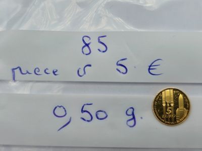 deux feuilles de papier sur lesquelles est posée une pièce d'or