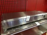 a metal shelf with an oven on it in a kitchen