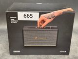 Sur la boîte de l'enceinte Bluetooth Marshall, on voit une main qui la tient.