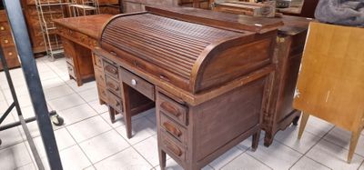 un bureau en bois à abattant et à tiroirs, dans une pièce