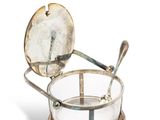 un saladier en verre sur lequel reposent une cuillère et un repose-cuillère