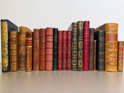several old books are lined up in a row on a table