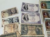 some old paper money sitting on top of a table next to each other