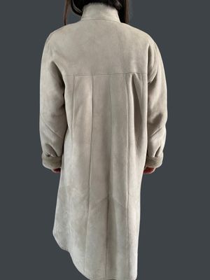 a woman in a white coat is standing on a gray background