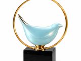 a blue glass bird sitting on top of a wooden stand