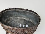 a metal bowl with a chain around it on a white surface