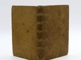 an old book sitting on top of a white surface