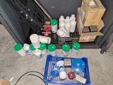 a blue basket filled with bottles and containers on the floor