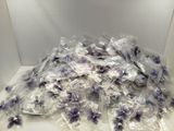 un tas de bonbons violets et blancs dans une boîte blanche