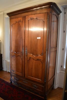 a large wooden cabinet in the middle of a living room