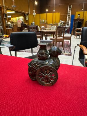 a vase sitting on a red table in the middle of a room