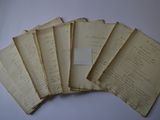 six old papers are stacked on top of each other on a table