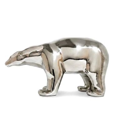 une statue en argent représentant un ours polaire sur fond blanc