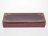 an old red box with a gold trim on it